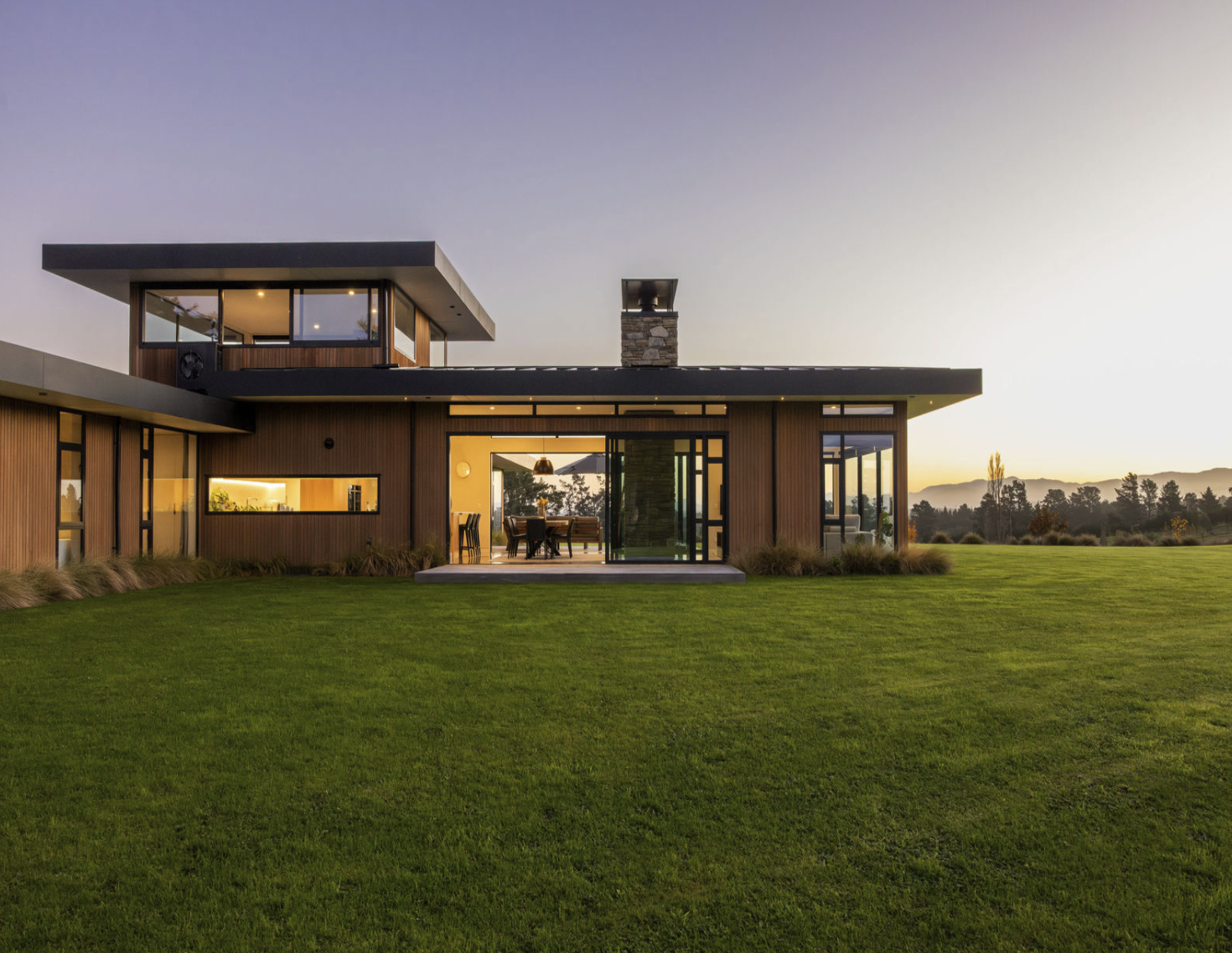 Modern house with a wooden exterior, large glass sliding doors and a spacious deck